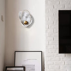 White marbled sconce unlit on a corner wall, next to painted white brick and a wall-mounted screen.
