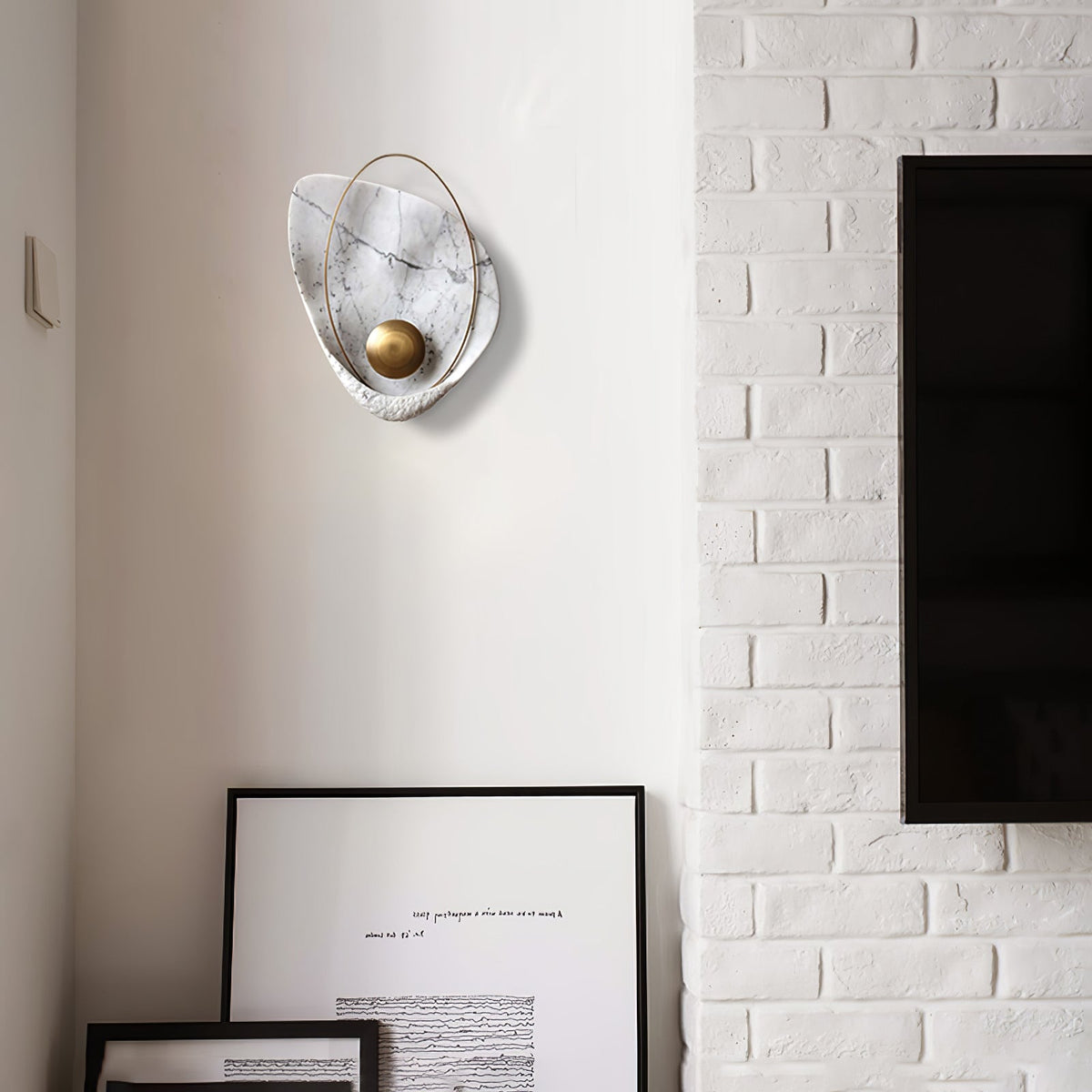White marbled sconce unlit on a corner wall, next to painted white brick and a wall-mounted screen.