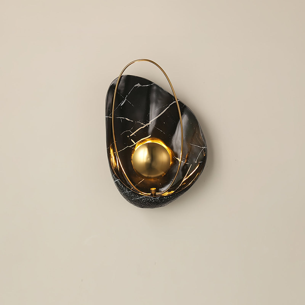 Black marbled sconce lit straight on against a beige wall, white veining across the dark shell.