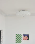 This Clérachic ceiling light, shown unlit, sits close to a corniced ceiling corner with colourful pop-art prints below.