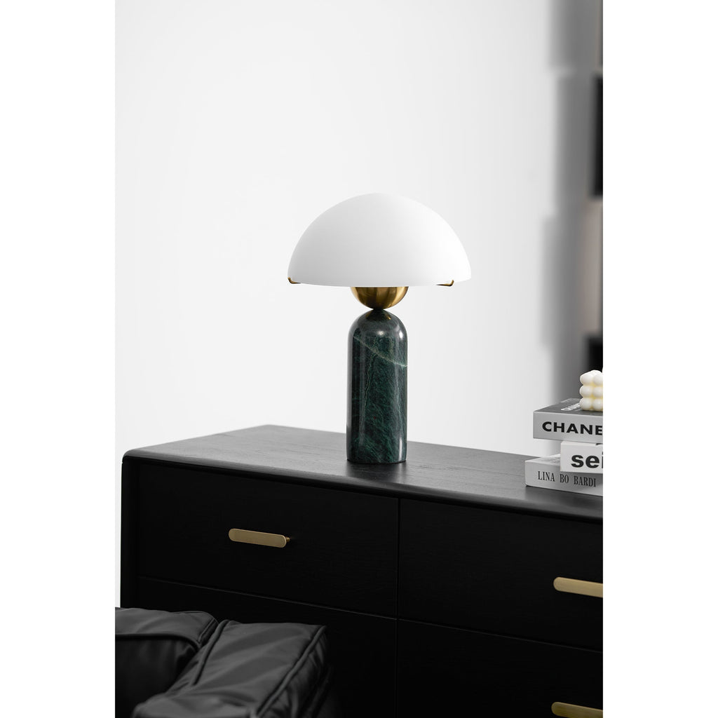 Green marble Veviniel lamp unlit on a black dresser, seen from across the room.