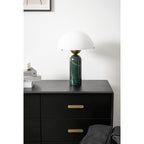 Green marble Veviniel lamp standing unlit on a black chest of drawers in a bright room.