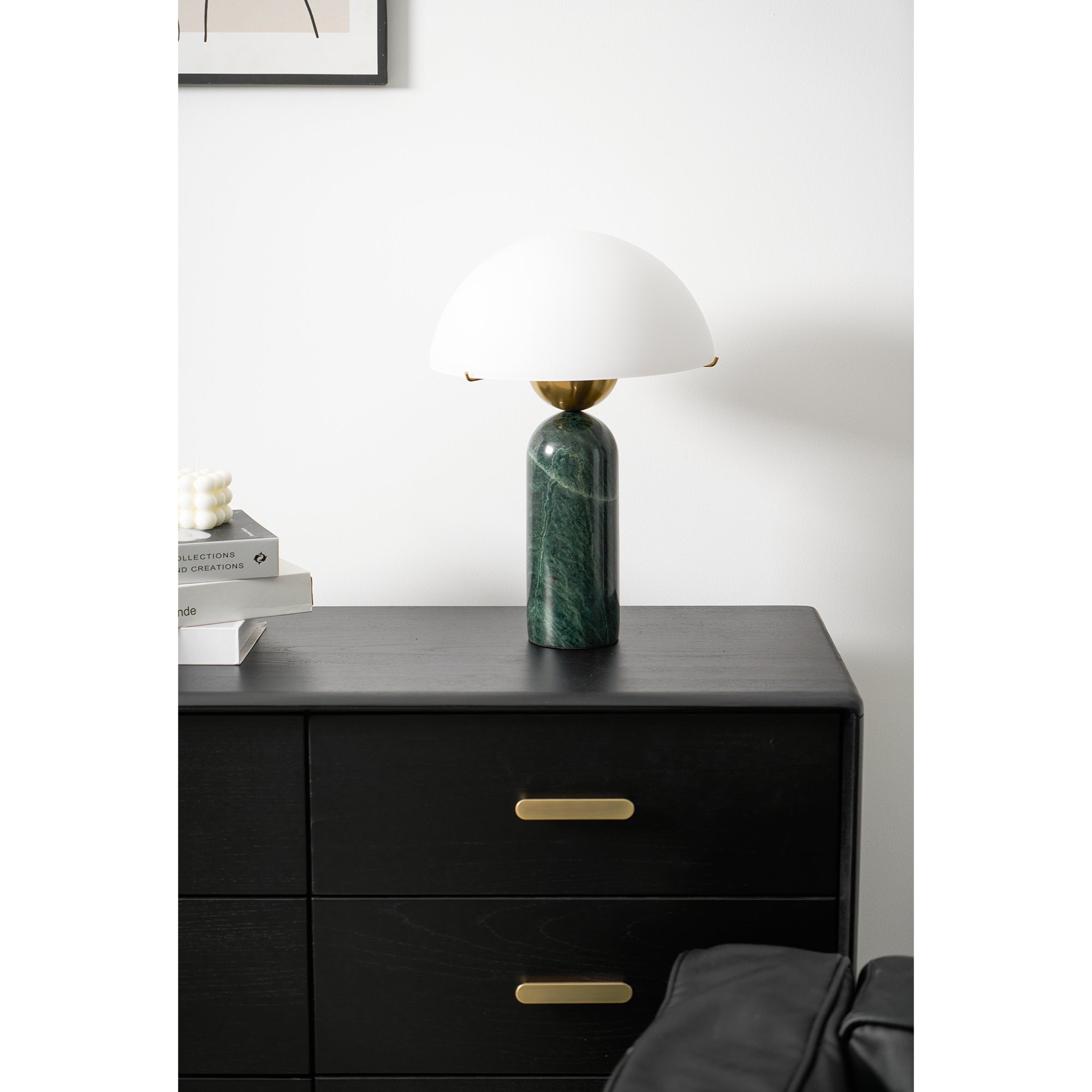 Green marble Veviniel lamp standing unlit on a black chest of drawers in a bright room.