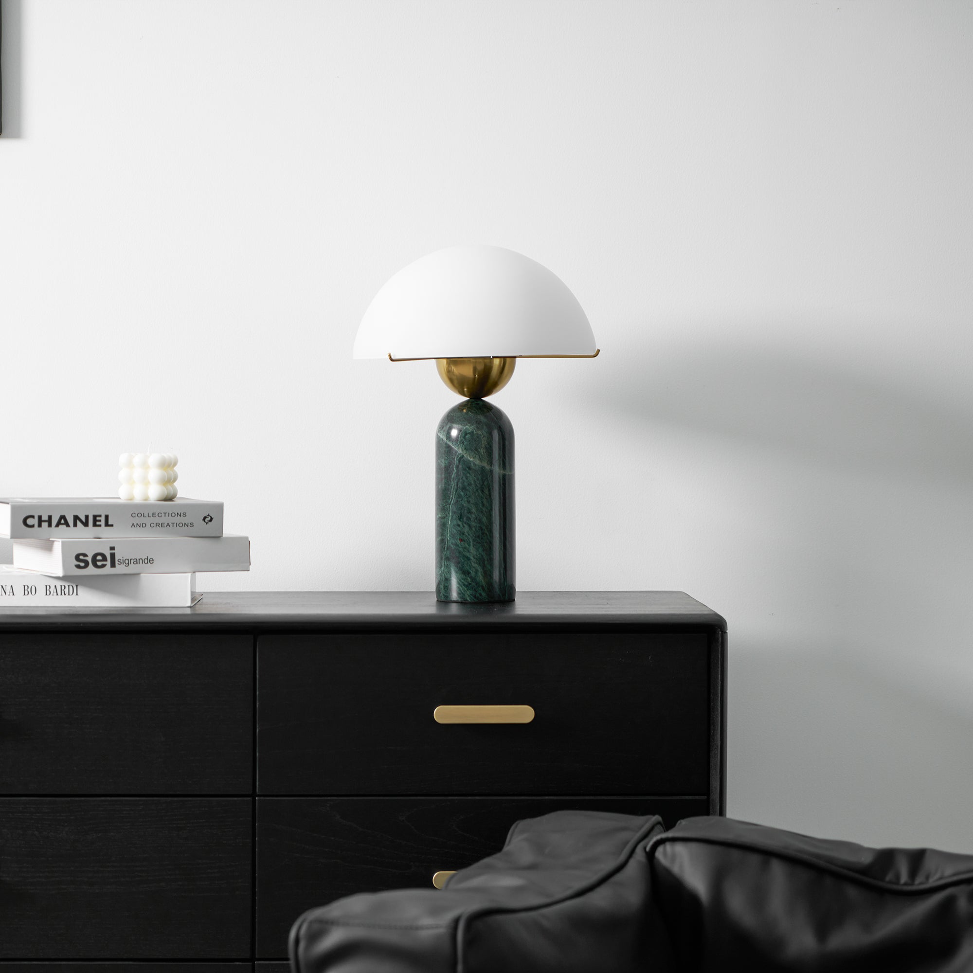 The green marble Veviniel lamp unlit on a black sideboard, shown at a distance for scale.