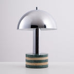 Clérachic lamp lit straight-on against the grey backdrop, the glow ring clearly visible beneath the chrome dome.