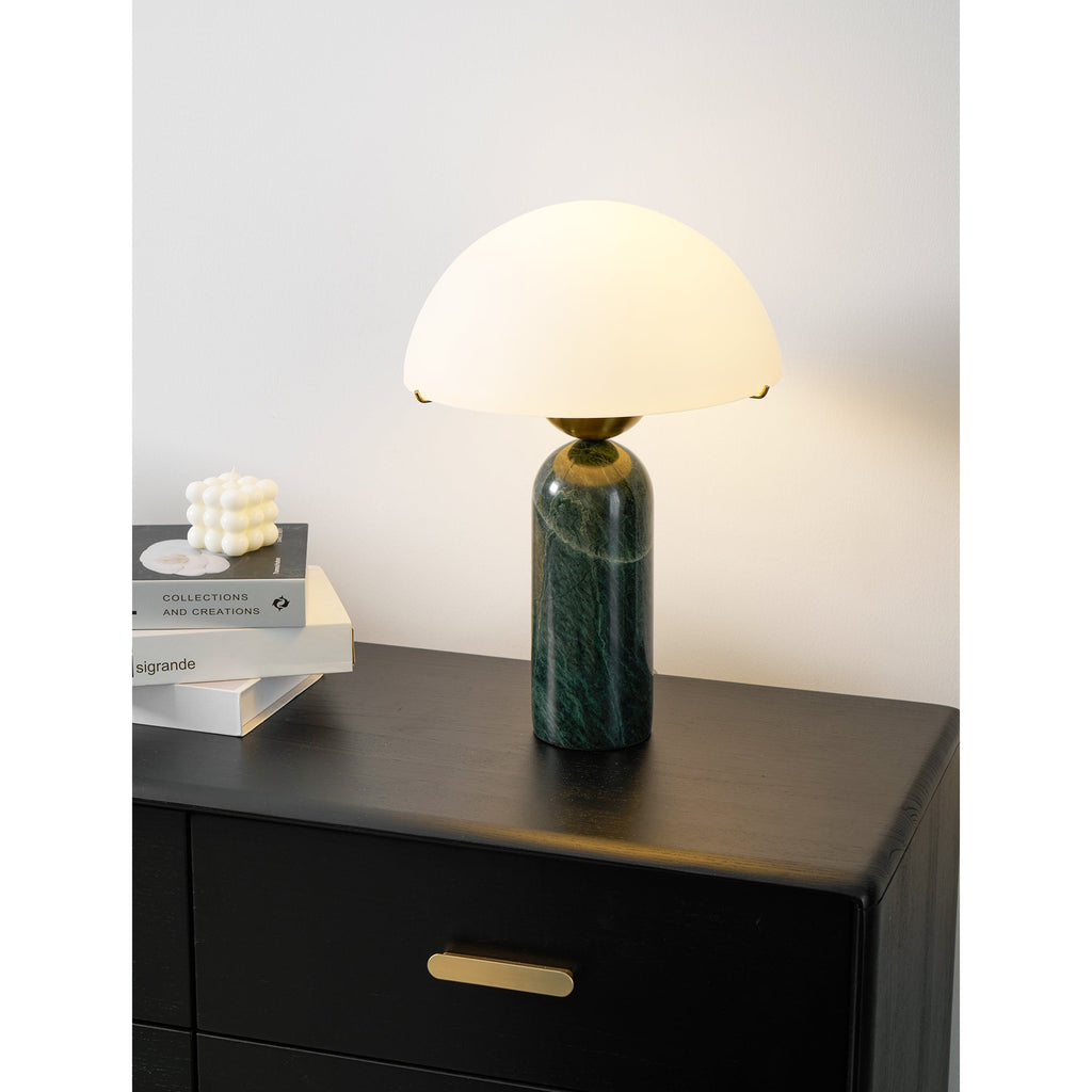 Close view of the green marble Veviniel lamp lit, the whole dome shade glowing softly.