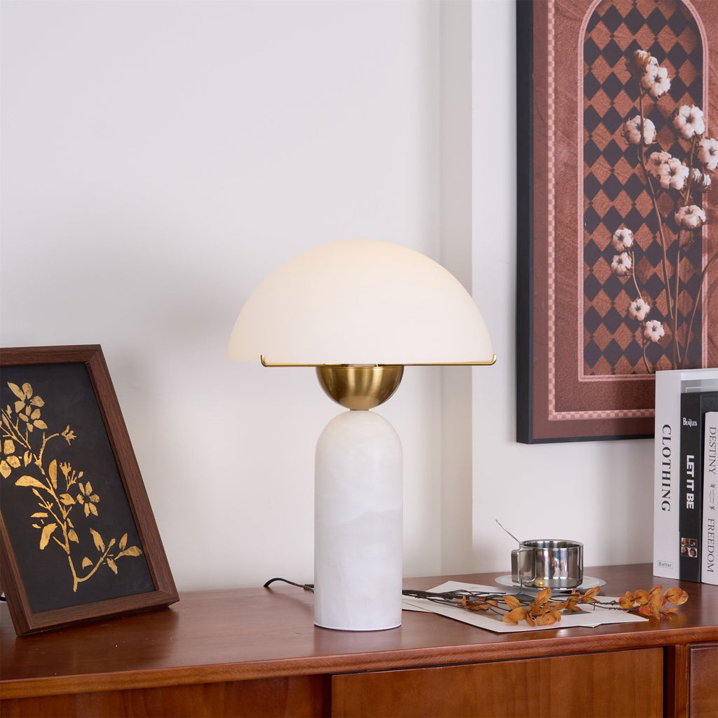 Veviniel lamp on a wooden sideboard seen slightly from below, brass shade rim edge in view.