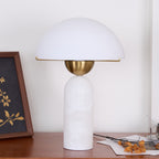 Veviniel lamp with white alabaster base on a walnut sideboard, brass shade rim catching the light.