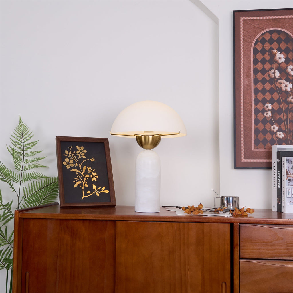 Veviniel lamp with white alabaster base on a teak sideboard, framed by a fern and botanical print.