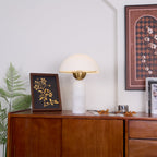 Veviniel lamp with white alabaster base on a teak sideboard, framed by a fern and botanical print.