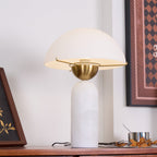 Veviniel lamp on a wooden sideboard, viewed from above so the brass bowl and bulb socket under the shade show.