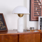The Veviniel lamp on a wooden sideboard with the shade's underside and brass fitting in view.