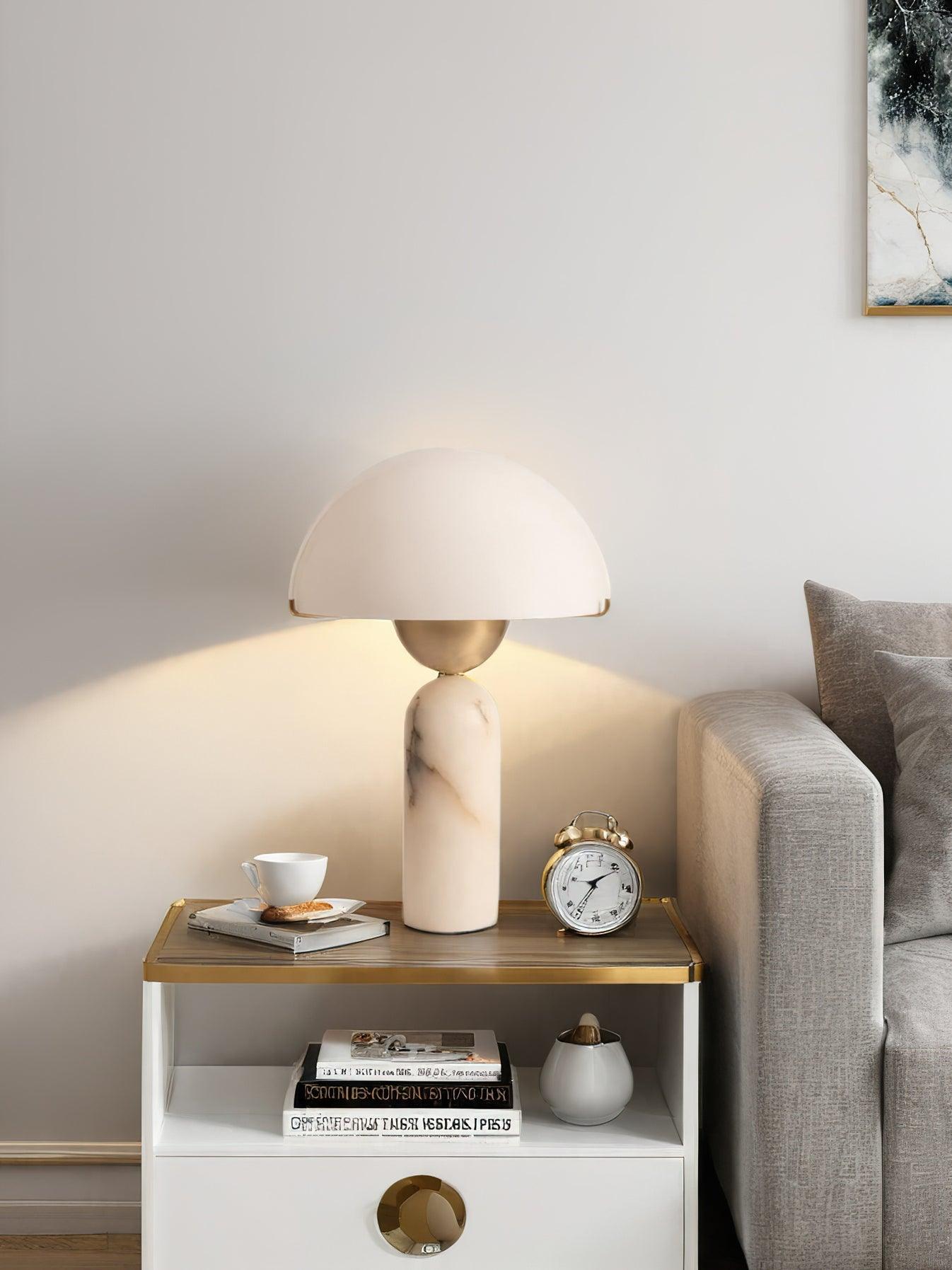 Veviniel lamp lit beside a sofa, warm light spilling onto the wall behind the clock and teacup.