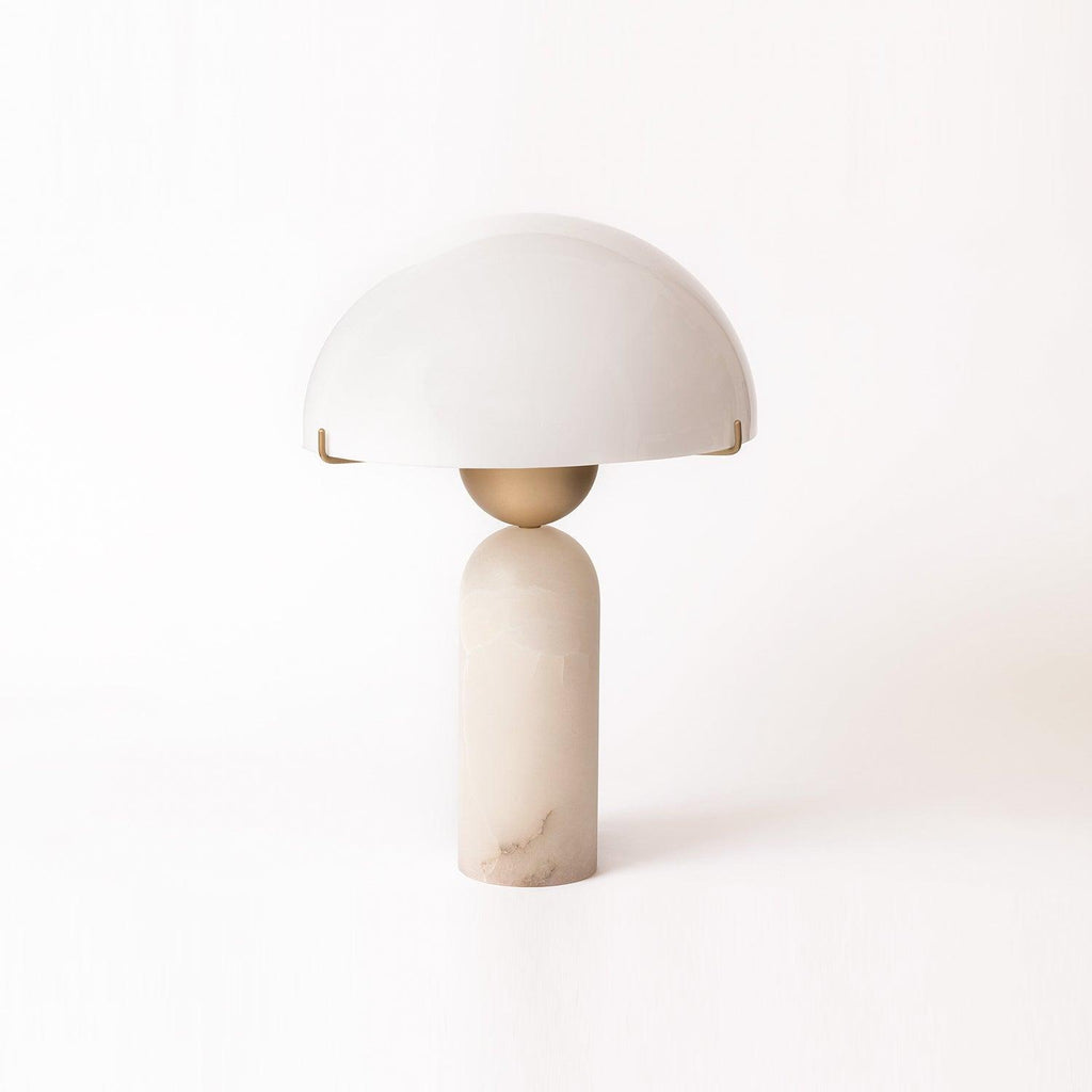 Studio shot of the Veviniel lamp on a white sweep, the stone column showing warm honey veining.