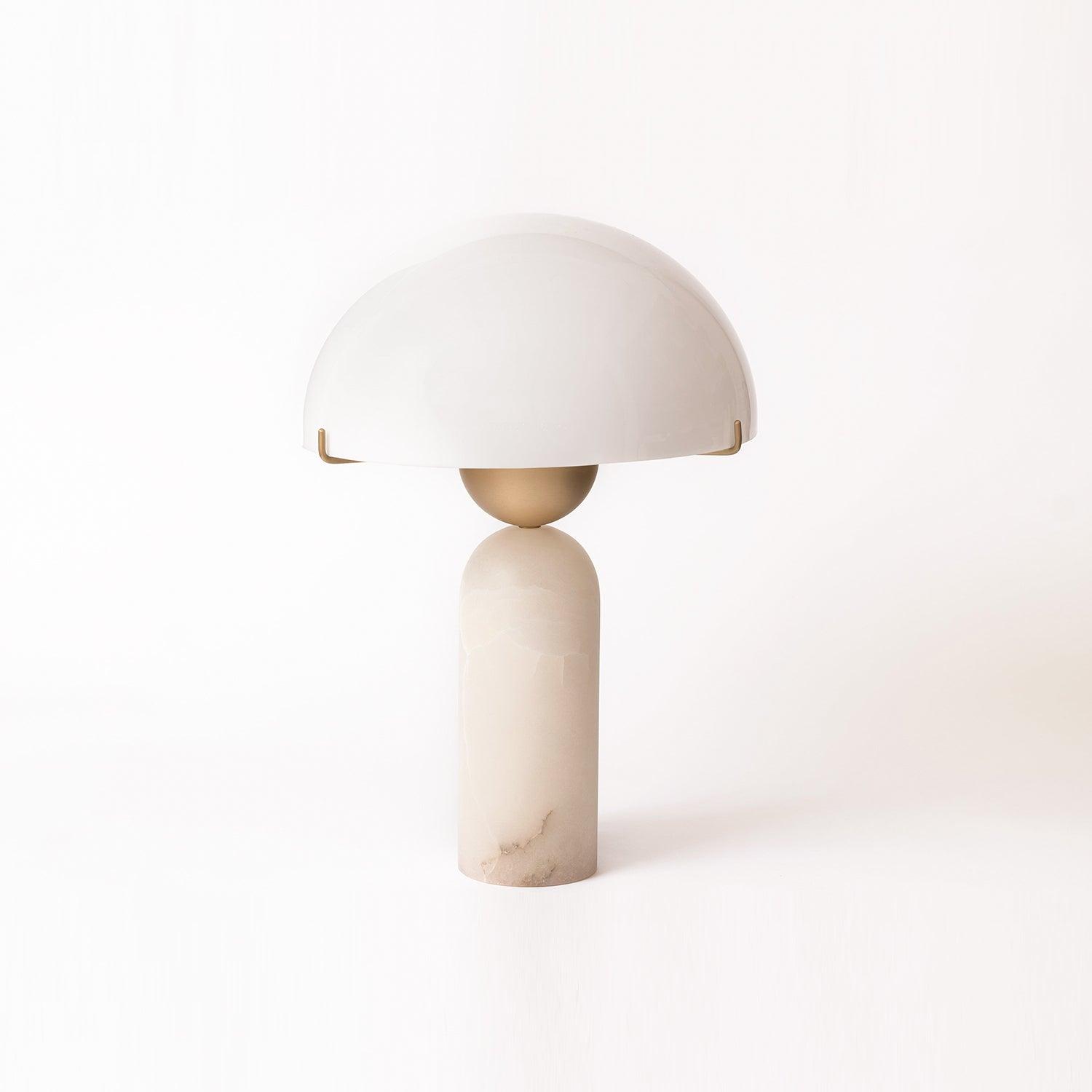 Studio shot of the Veviniel lamp on a white sweep, the stone column showing warm honey veining.
