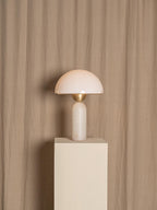 Veviniel lamp displayed on a pale plinth against a draped linen backdrop, shown at full height.