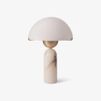 The Veviniel table lamp unlit on a white background, showing the soft blush tone of the alabaster shade.