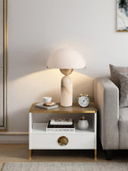 Veviniel lamp lit on a two-tier side table by a sofa, glow fanning out across the wall.