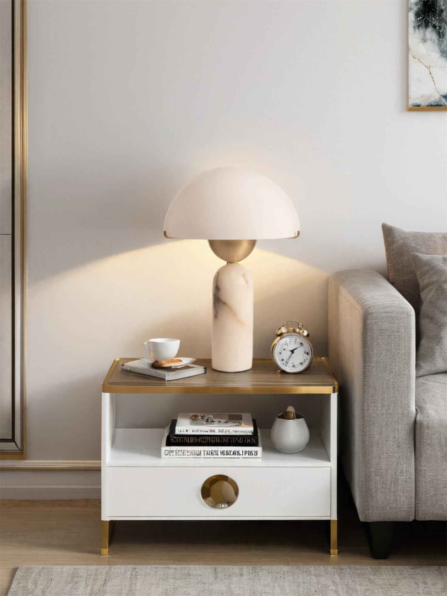 Veviniel lamp lit on a two-tier side table by a sofa, glow fanning out across the wall.