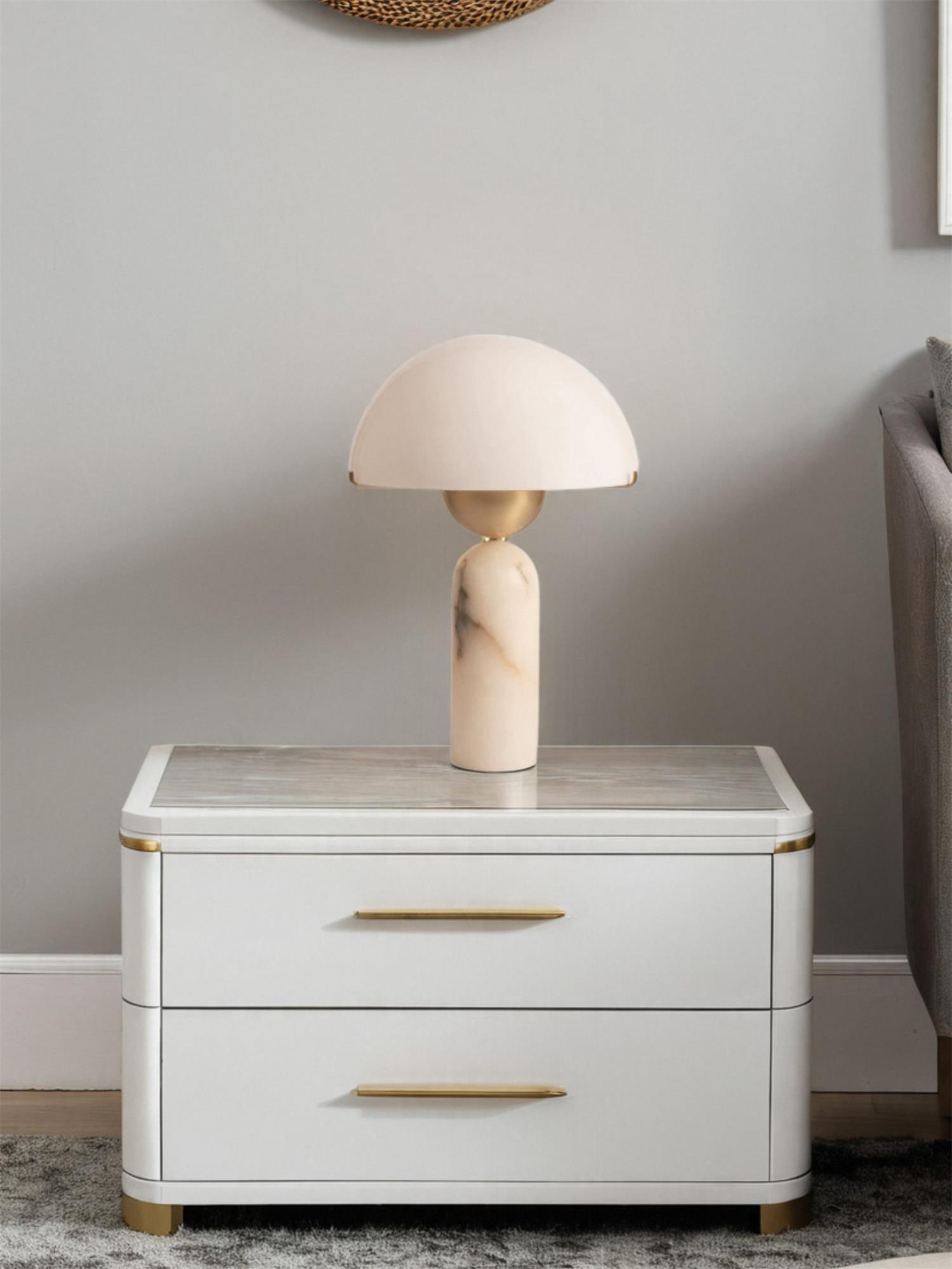 The Veviniel lamp seen from across the bedroom on a lacquered nightstand, showing its compact scale.