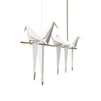 Bird chandelier suspended over a table with warm glow
