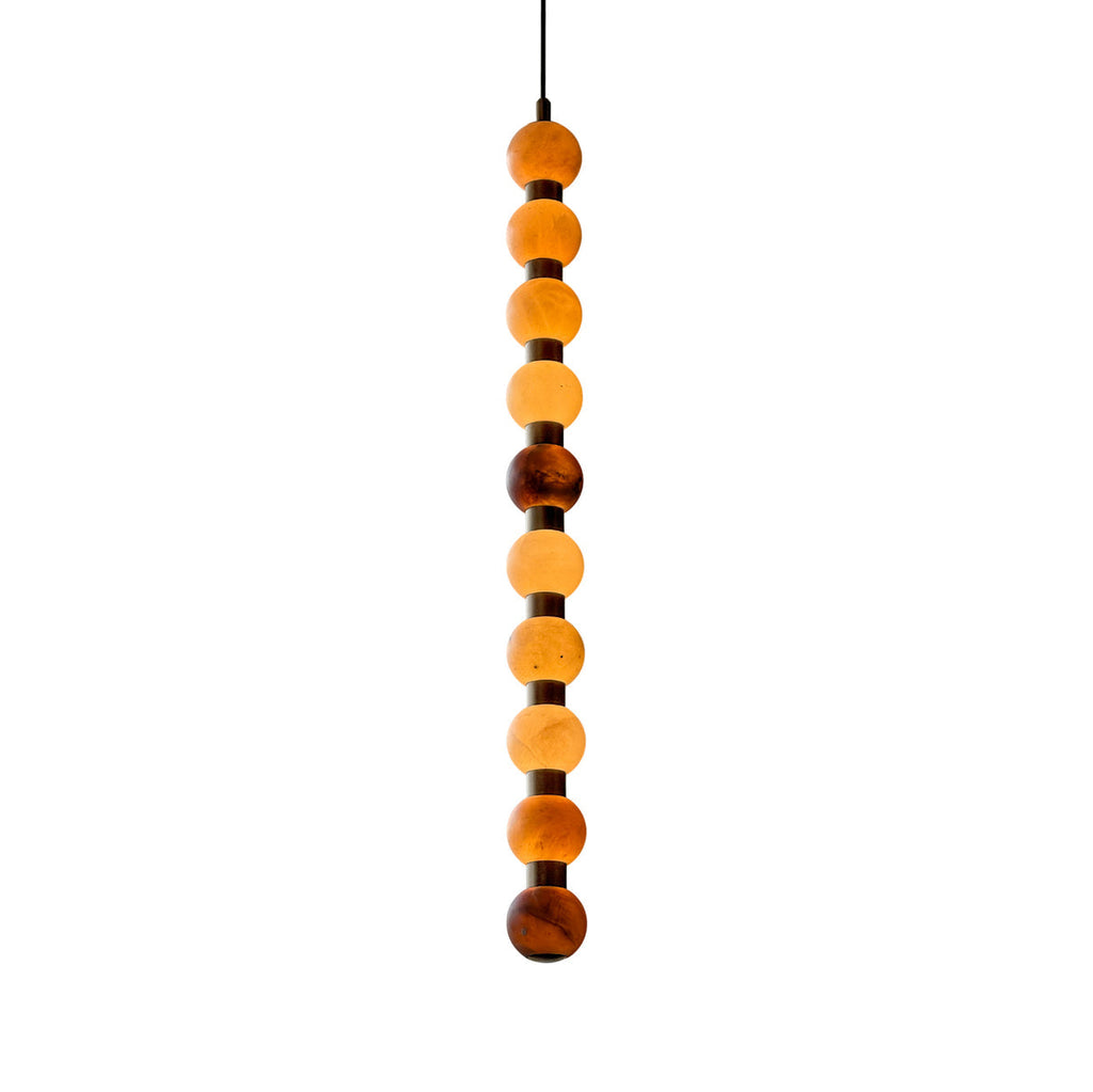 Photographed on white, this Clérachic pendant's alabaster spheres shift from amber to brown.