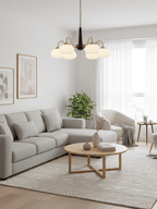 Six shades on this Clérachic chandelier glow above a grey corner sofa and round wood coffee table.