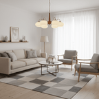 In a living room with a grey checked rug, this Clérachic chandelier's cream shades glow above two armchairs.