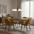 This Clérachic chandelier hangs above a round table with mustard-yellow chairs and a white pedestal base.