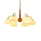 Against a white backdrop, six cream shades on this Clérachic chandelier circle its walnut pole.