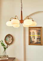This Clérachic chandelier hangs near a gilt-framed picture and a small oval mirror in a warm-toned room.