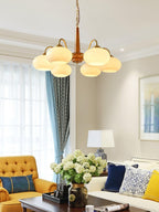 In an eclectic living room with a mustard tufted armchair, this Clérachic chandelier's six shades glow warmly.