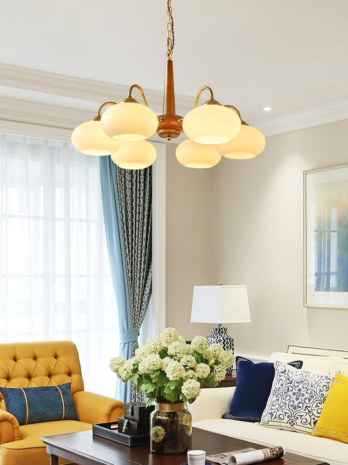 In an eclectic living room with a mustard tufted armchair, this Clérachic chandelier's six shades glow warmly.