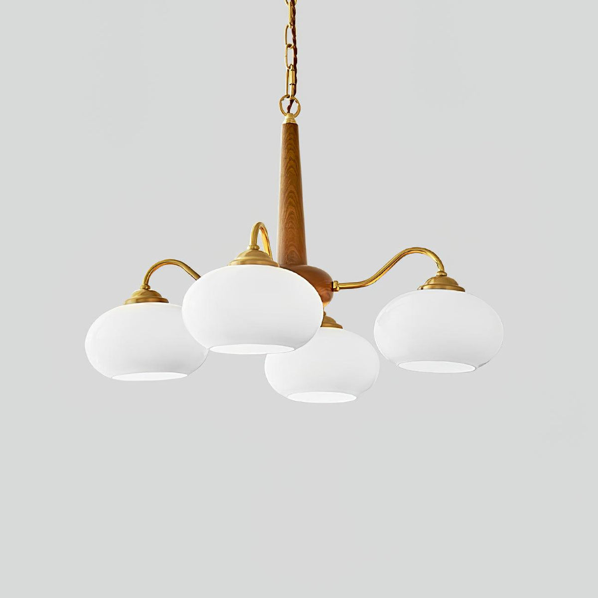 Four white glass shades on this Clérachic chandelier are shown against a plain grey backdrop.