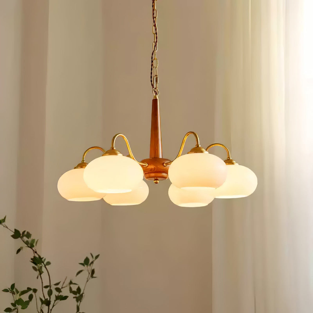 Seen close against sheer curtains, this Clérachic chandelier's cream shades cluster tightly around its walnut pole.