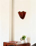 Petalia wall sconce curved shade lit with a gentle warm glow