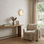 Alabaster wall sconce with gold finish on neutral wall