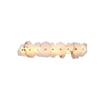 The nine-head alabaster wall lamp at full width, lit slabs staggered along one long horizontal bar.