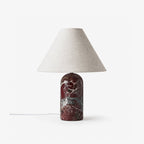 Clérachic lamp in a deep burgundy marble finish, shown unlit against a plain white backdrop with its cord visible.