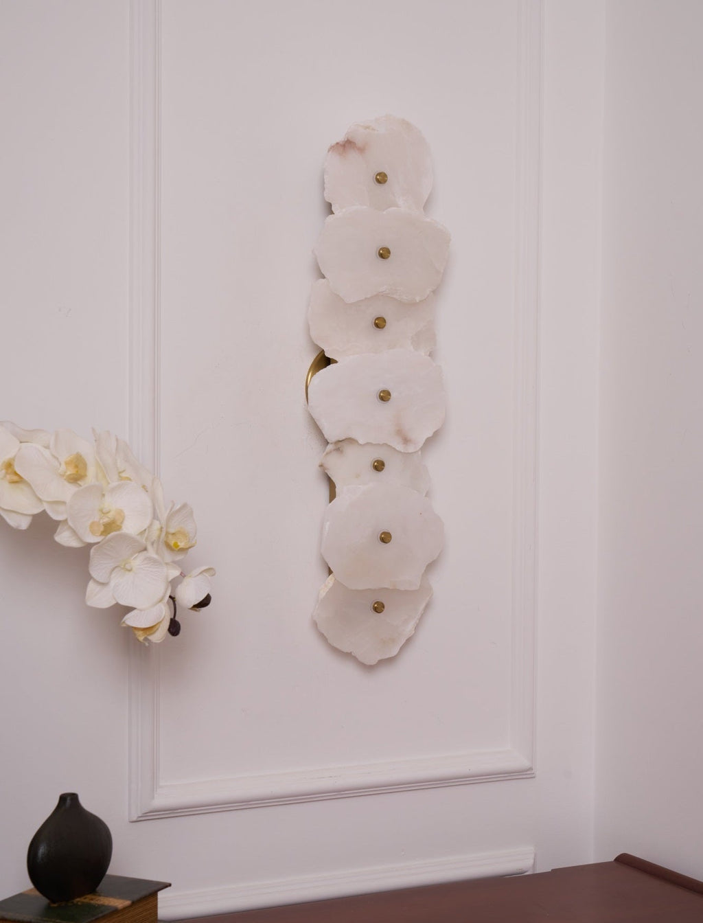 Alaeila alabaster wall light switched off, its petal-shaped stones flat white in daylight.