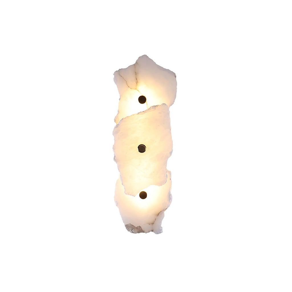 Three-head alabaster wall lamp stacked vertically, each stone slab lit warm and pinned by a brass stud.