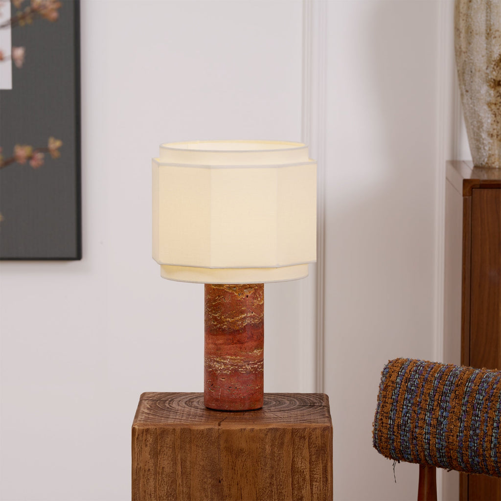 Framed art sits to the left and a woven chair arm to the right of this glowing Clérachic table lamp on a wood block.