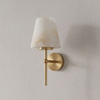 Straight-on against a plain backdrop, this Clérachic wall light's alabaster cone catches the light in brushed brass.