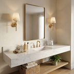 Either side of a tall brass-framed mirror, two brushed brass Clérachic wall lights sit above a floating marble vanity.