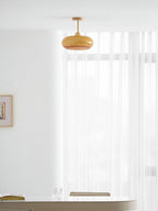 Plafonnier ceiling light orange finish glowing in a styled interior