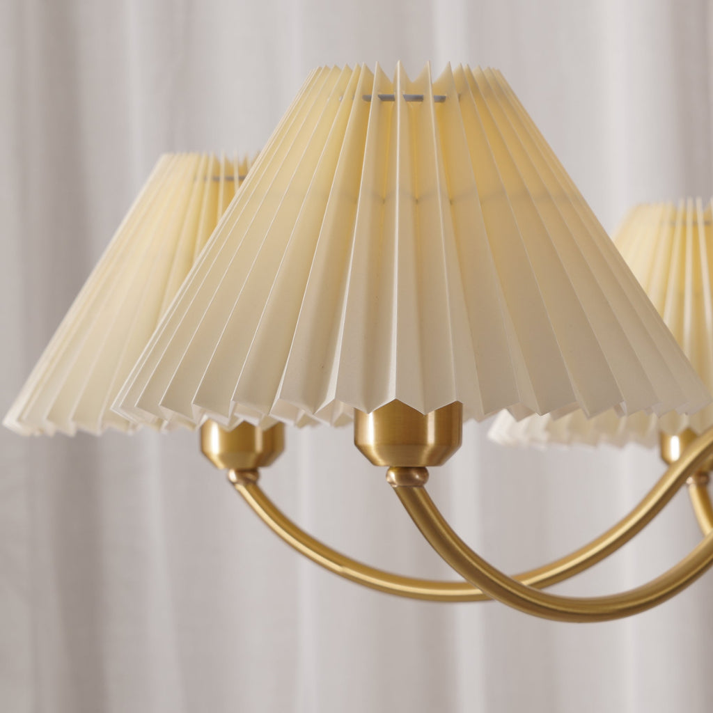 Close view of the fine pleats and brass fittings on this Clérachic chandelier's fabric shades.