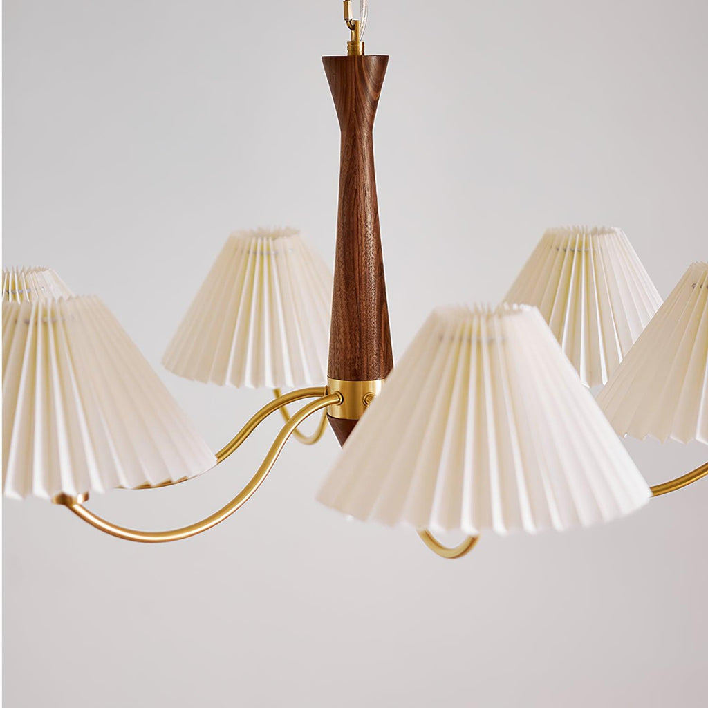 Close view of the turned walnut column and curved brass arms on this Clérachic chandelier, pleated shades fanning outward.
