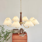 This Clérachic pendant's row of pleated shades catches the light beside a framed portrait and trailing green leaves.