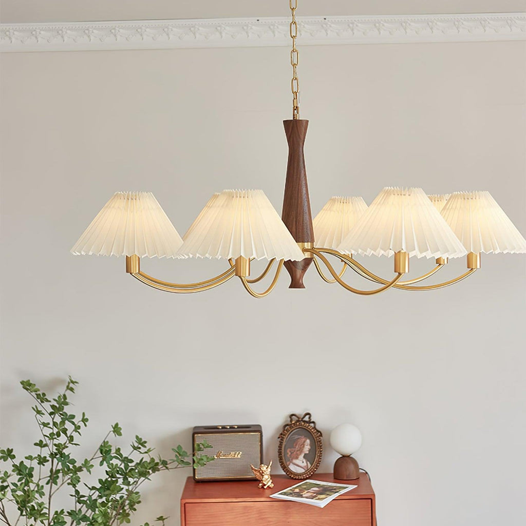 A different angle on this Clérachic chandelier shows its walnut column and pleated shades above the same dresser vignette.