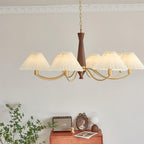 A different angle on this Clérachic chandelier shows its walnut column and pleated shades above the same dresser vignette.